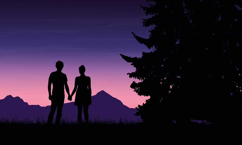 silhouette of a couple against a night sky with various hues of purple and pink mountain in the background and a tree to the right in the foreground